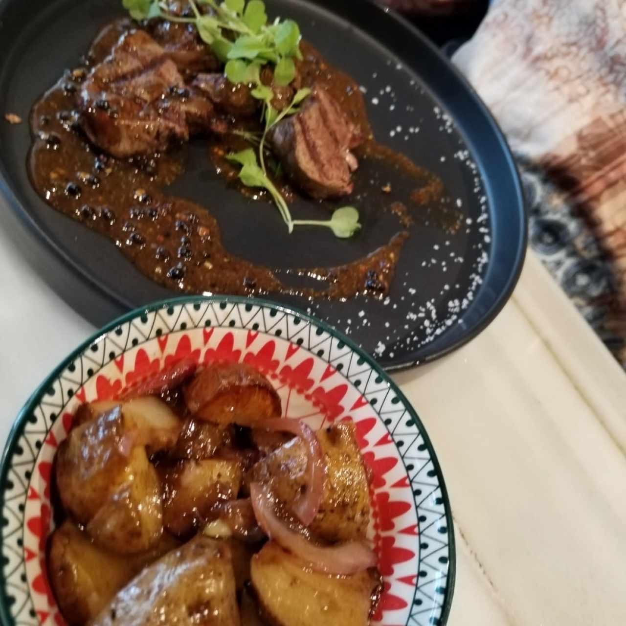 Medallones de entraña a la pimienta acompañados de papas salteadas con cebolla carmelizada