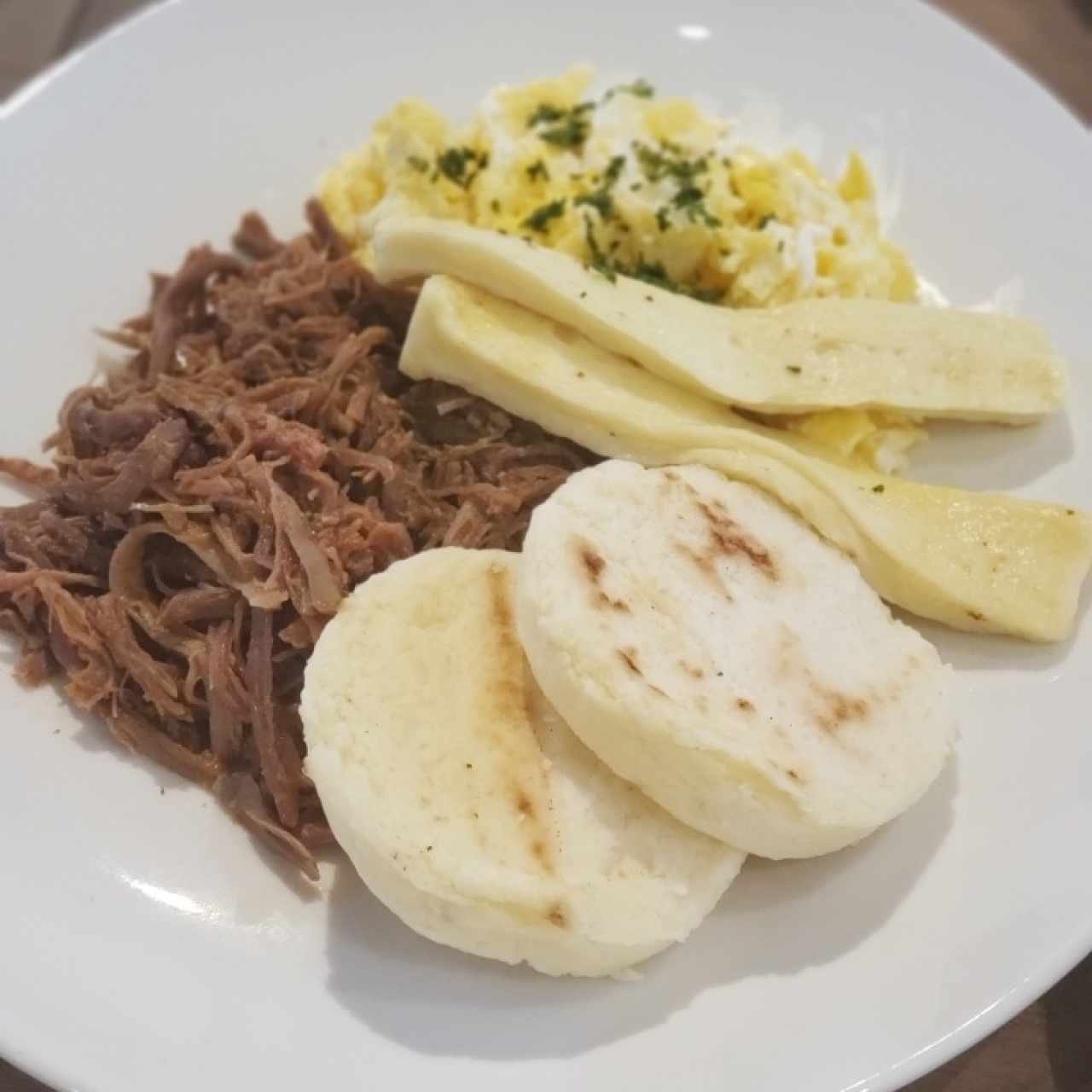 Ropa vieja con huevos, queso blanco y arepas