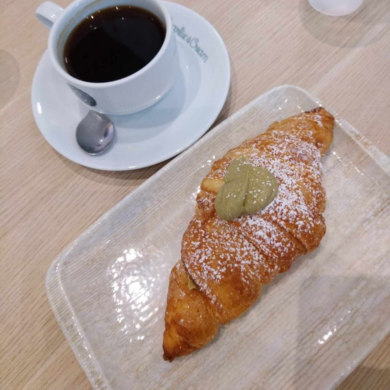 Croissant relleno de crema de pistacho y café americano. 