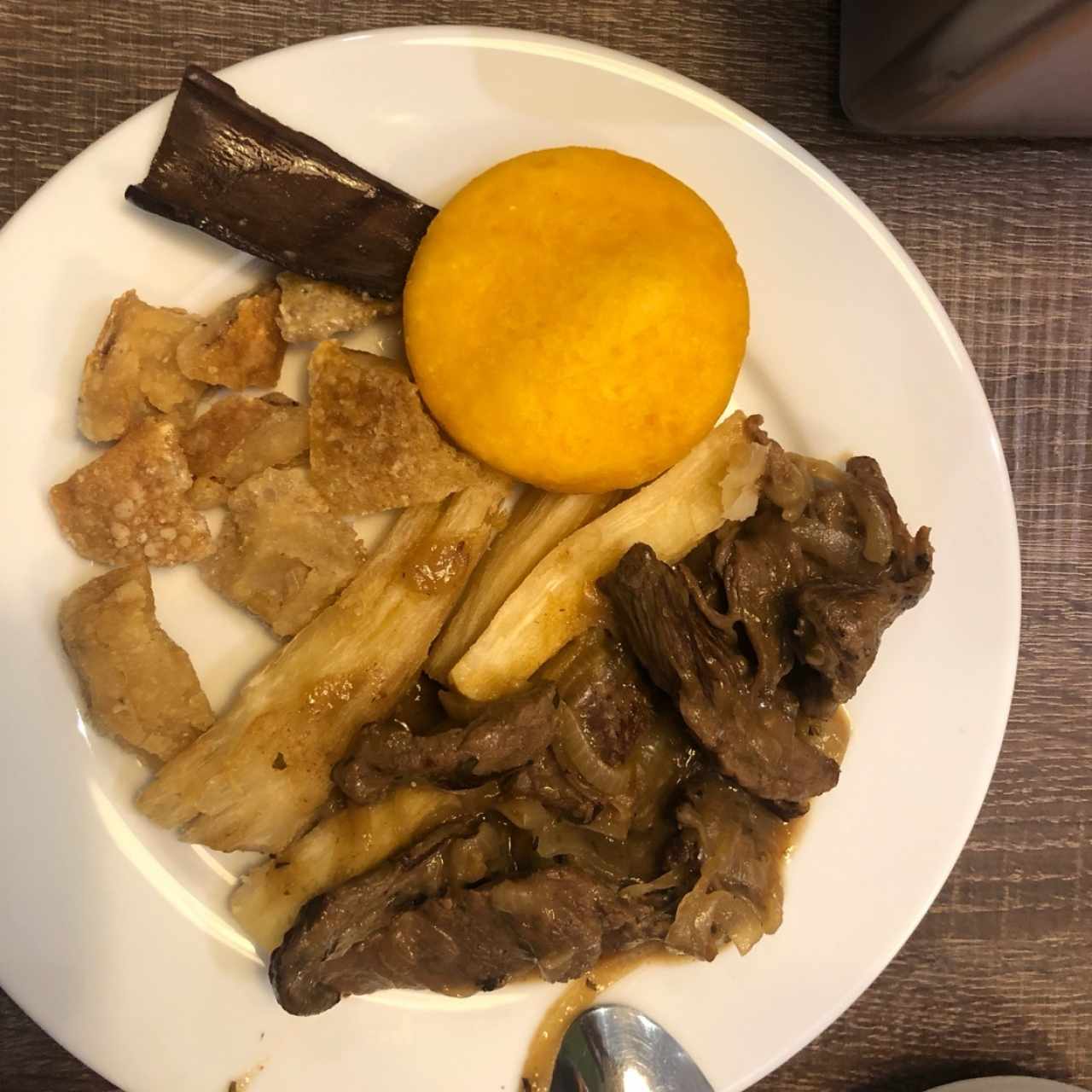 Bistec encebollado, tortilla, yuca frita y chicharrones