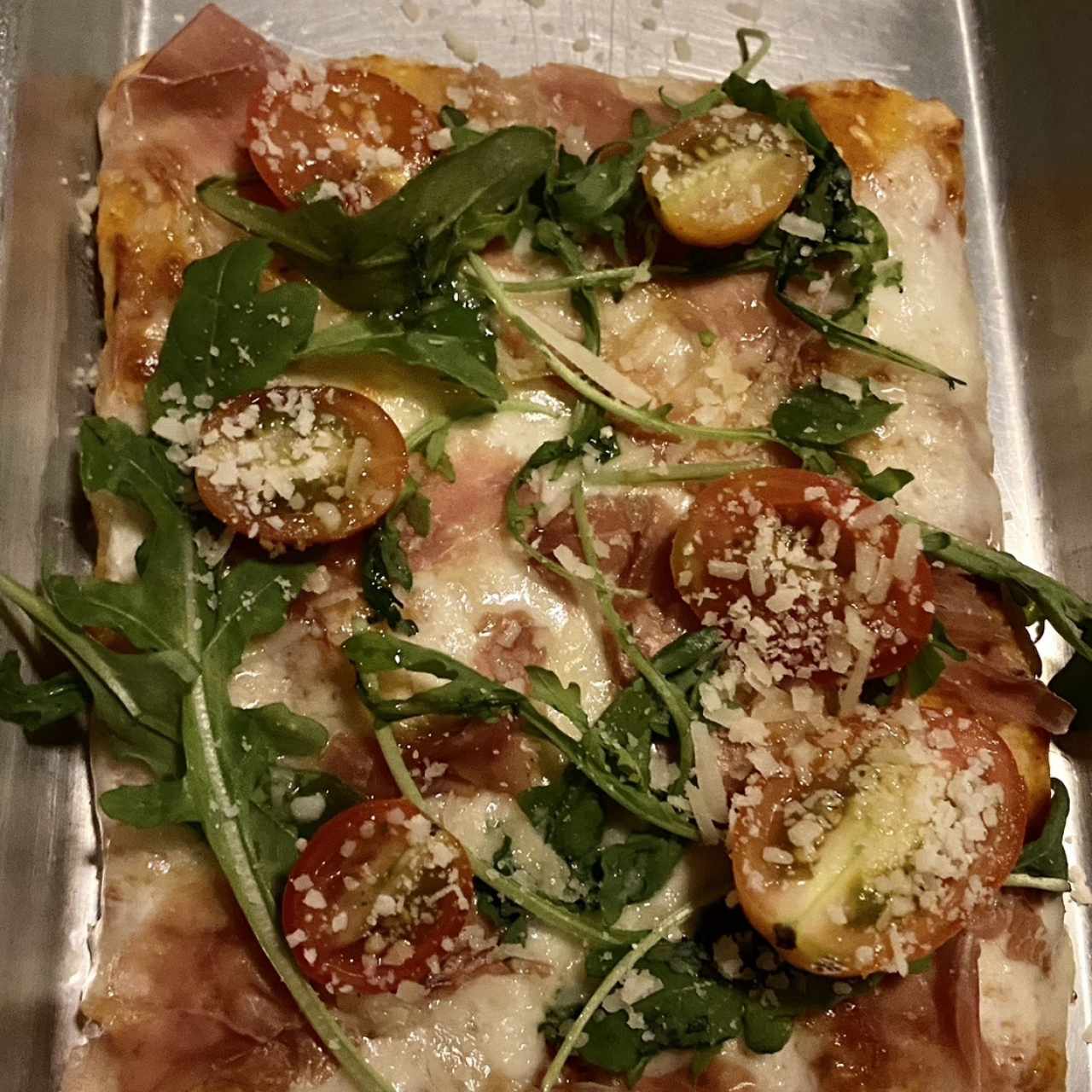 Pizza de arugula y tomates