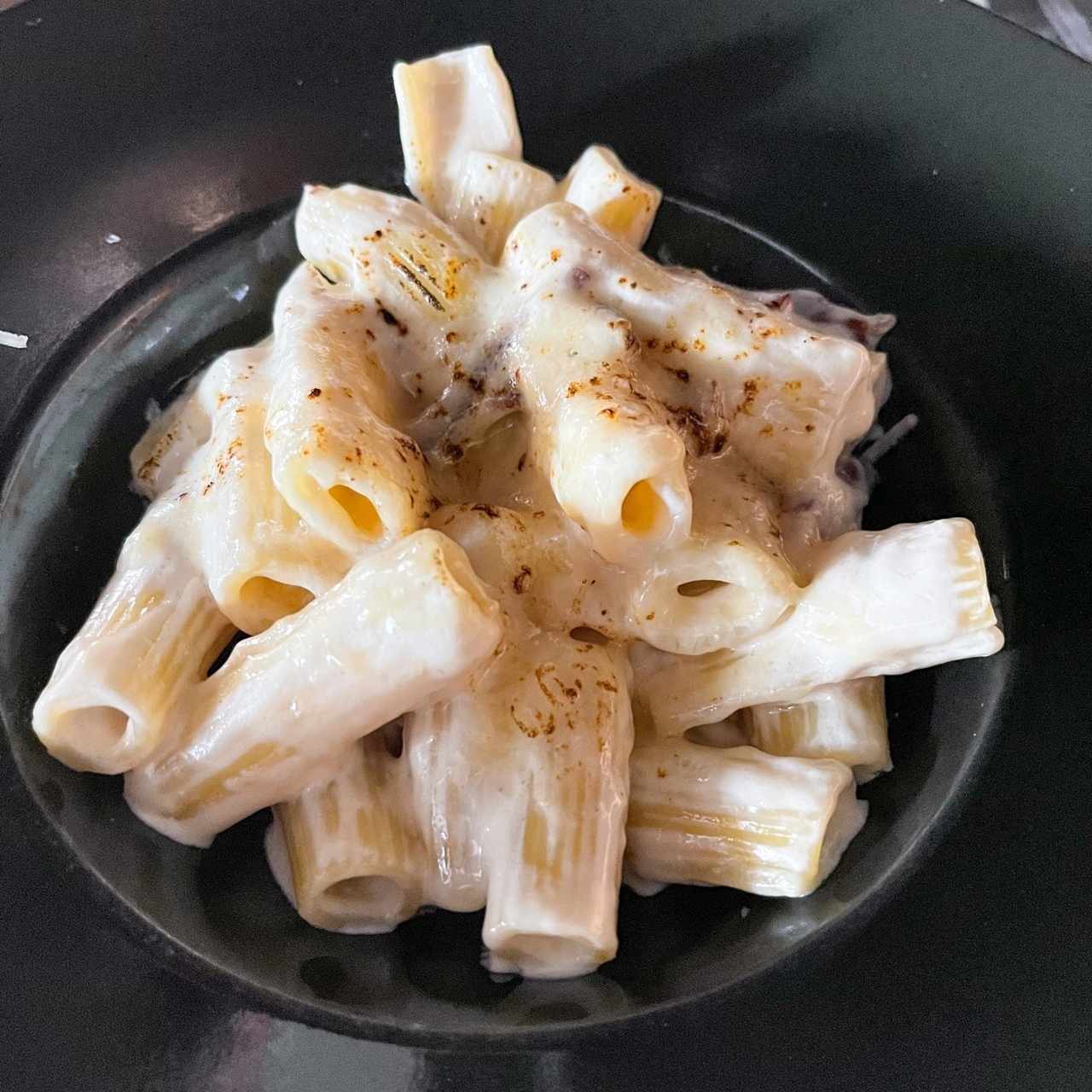 Rigatoni en crema de queso parmesano, queso suizo, jamon serrano y aceite de trufa