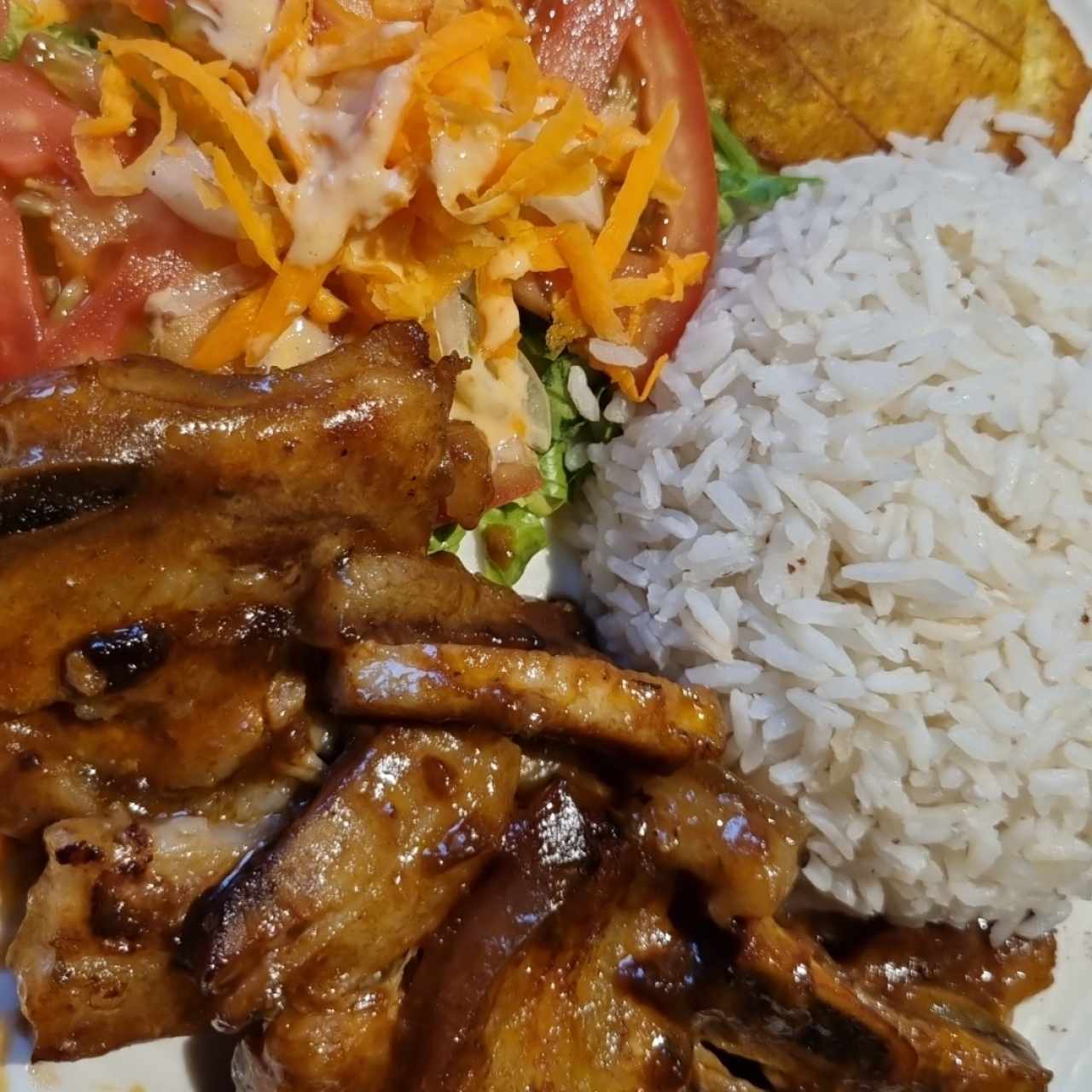 Costilla con arroz con coco, plátanos y ensalada. 