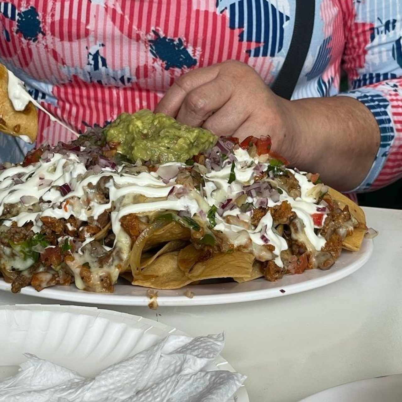 Nachos de Birria (Birria, cebolla, cilantro, queso fundido) con Crema Agria