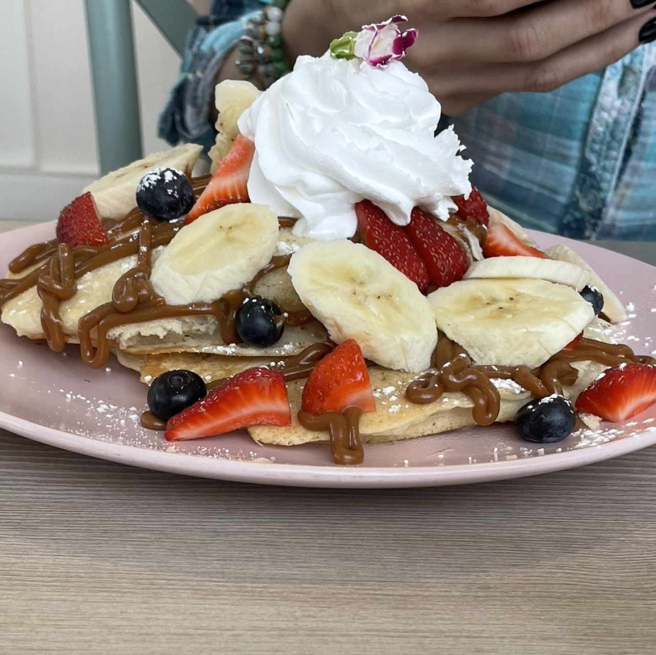 Pancakes con dulce de leche, banana, blueberries y fresas