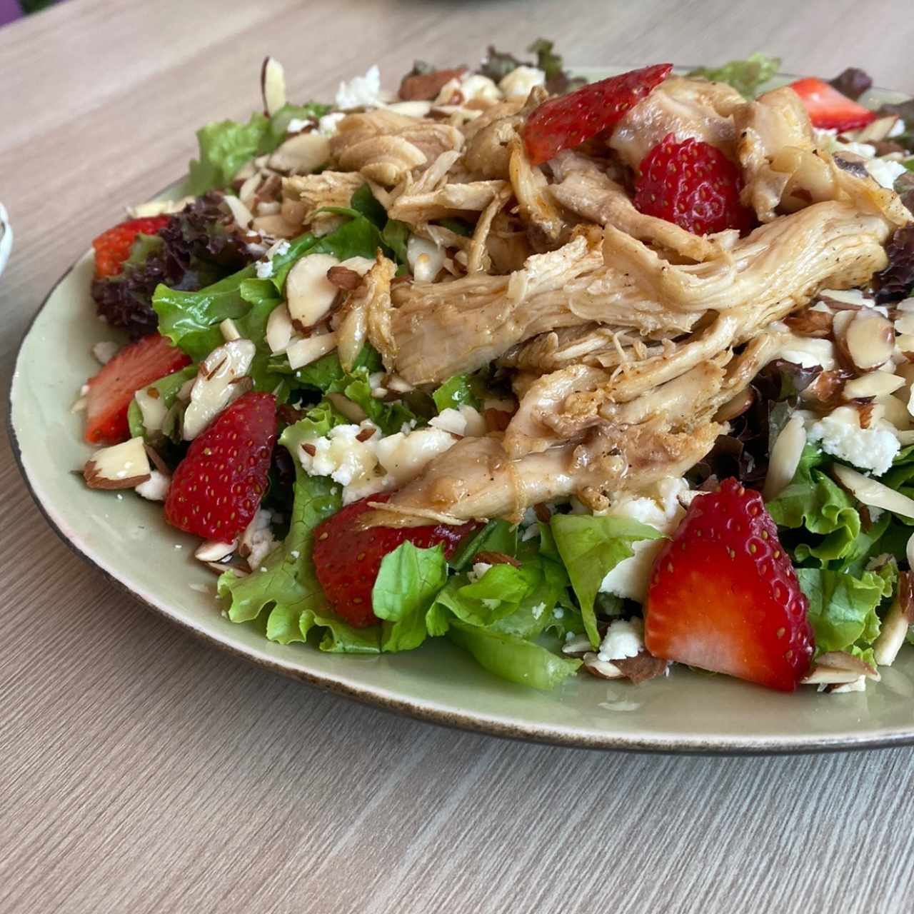 Ensalada de lechuga, fresas, almendras, queso feta y adicional el pollo 