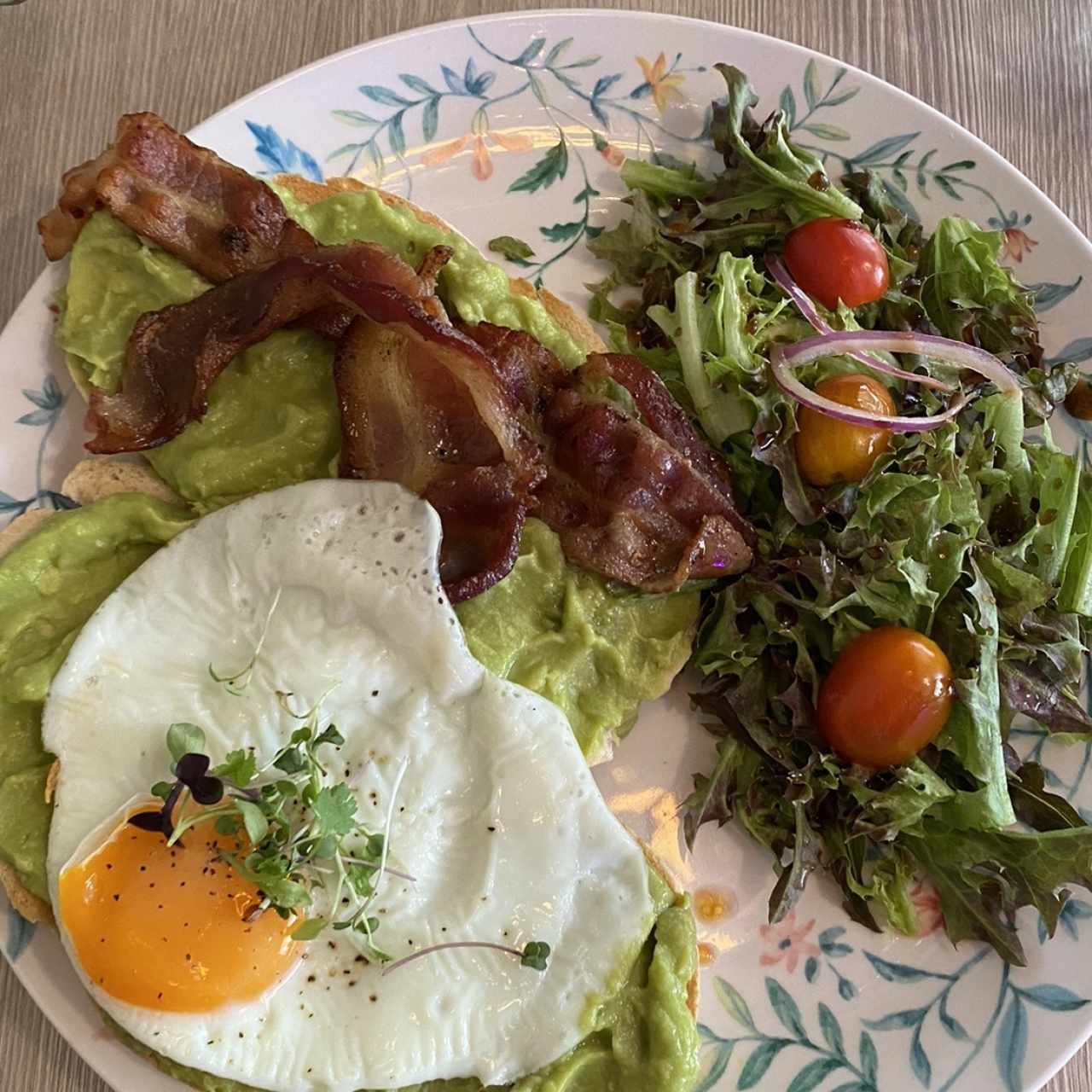 Avocado toast especial con aguacate, huevo frito, bacon dorado, lechuga y tomate cherry