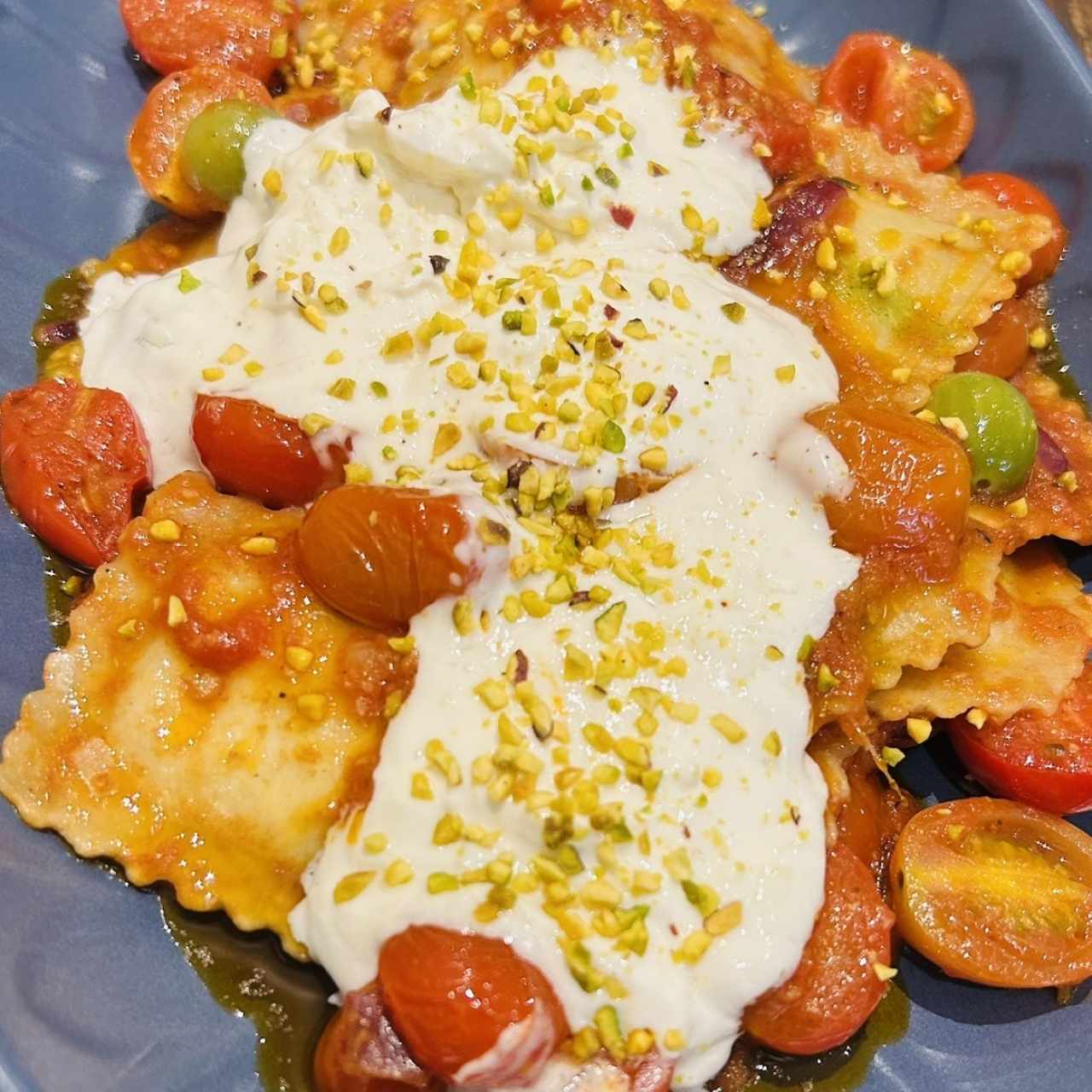 Ravioli de alcachofa con tomates confitados y straciatella