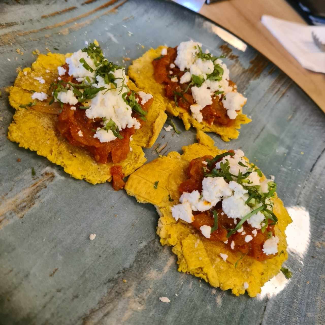 Patacones con salsa de tomate + queso feta. También viene con guacamole pero lo pedí sin.