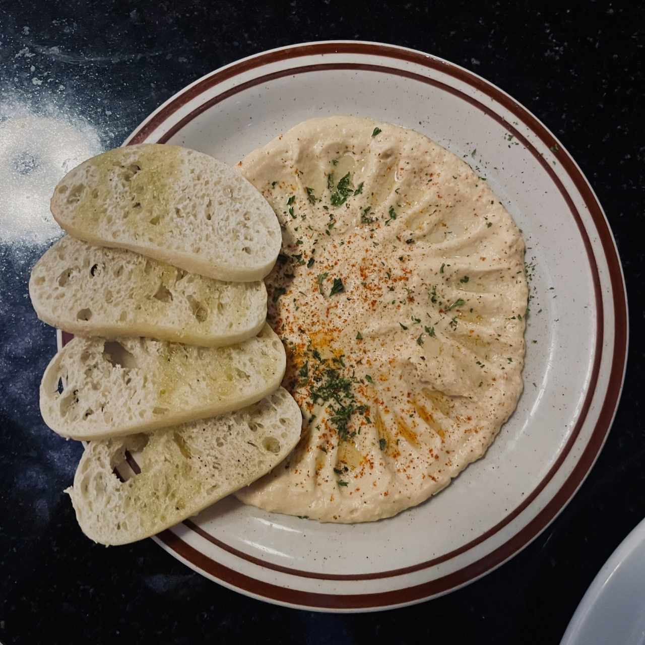 Hummus a base de garbanzos acompañado con láminas tostadas de pan ciabatta