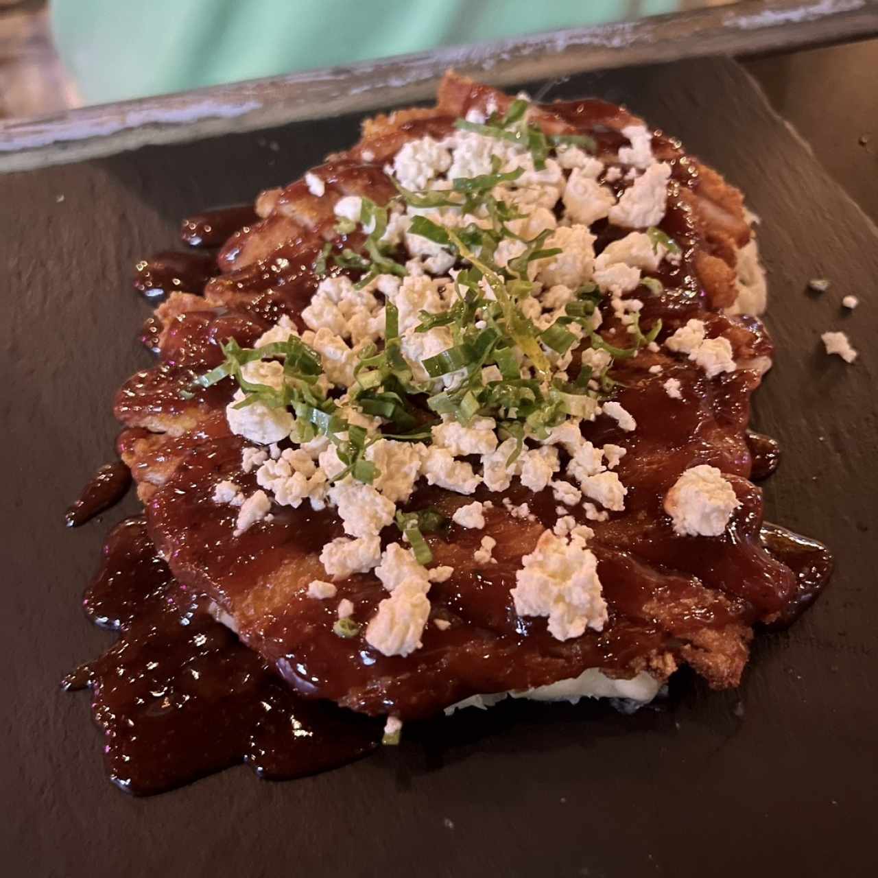 Milanesa de pollo en jalea de guayaba sobre una cama de puré de yuca al mojo