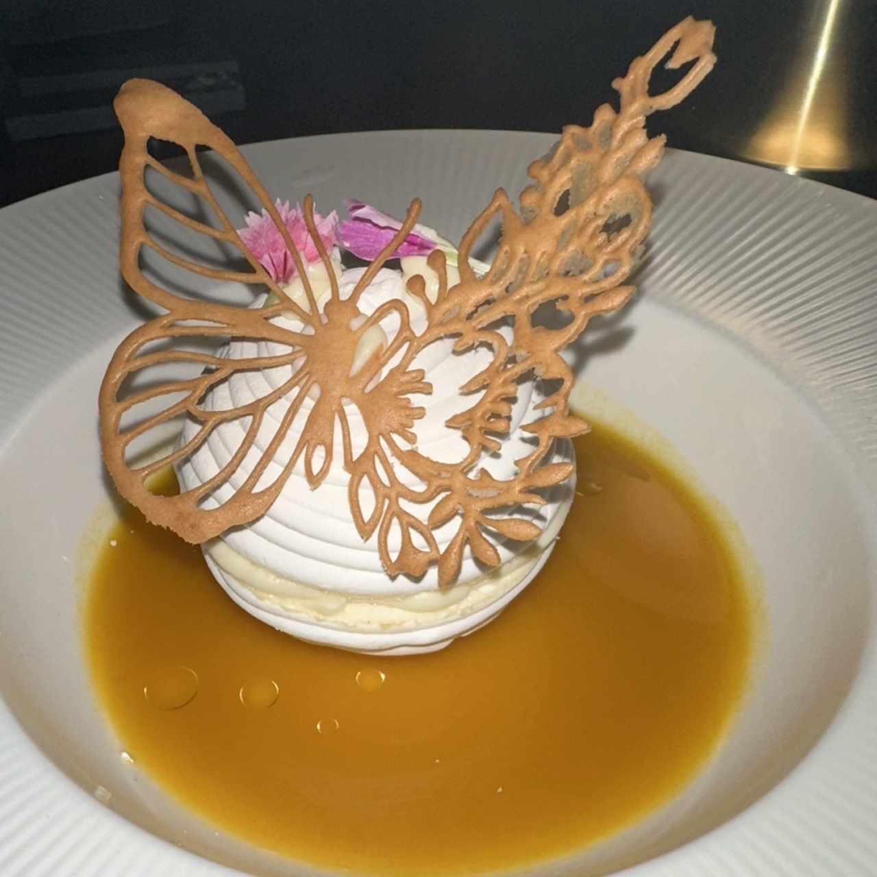 Delioso postre con merengue, sorbeto de maracuya y pepitas de marañon 