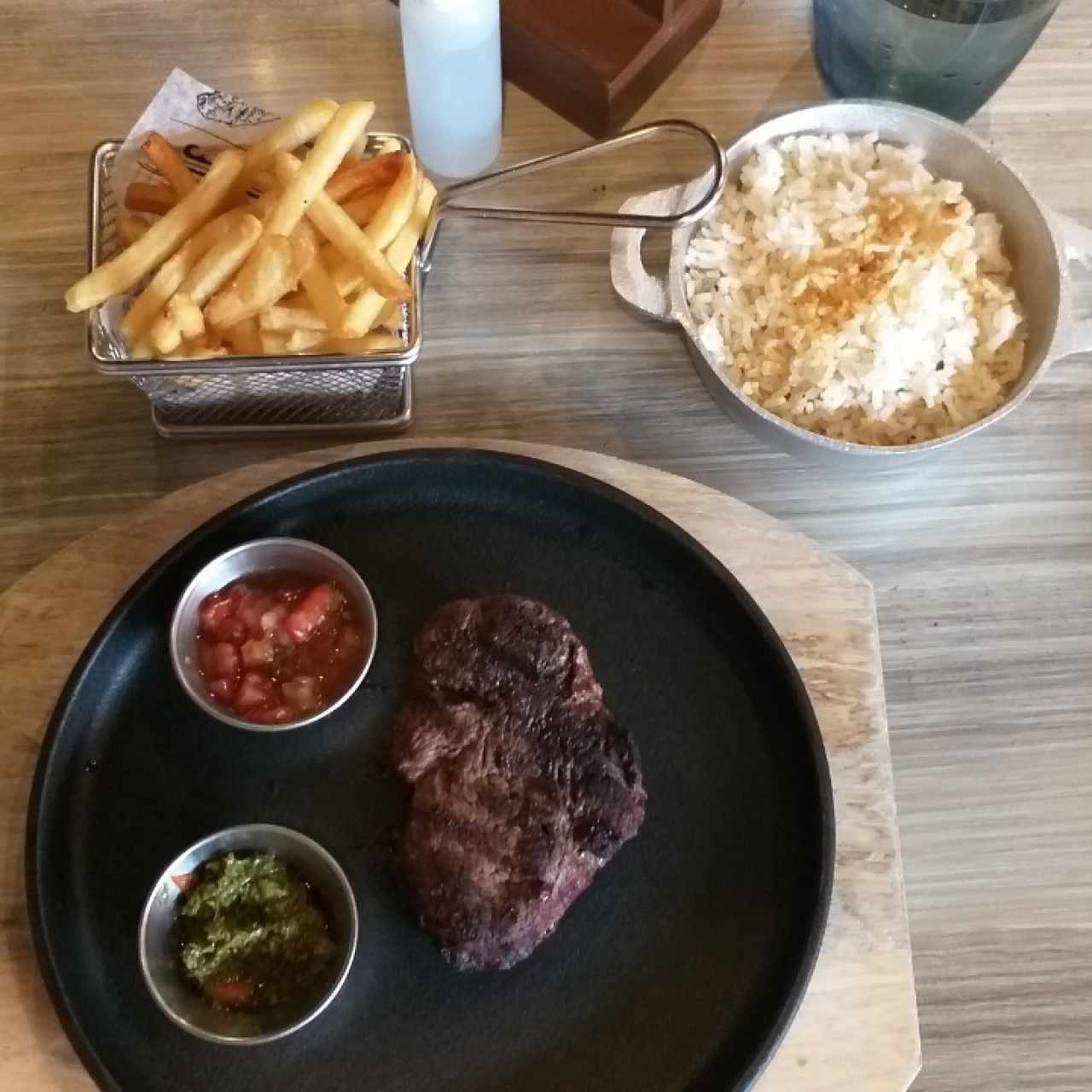 Filete de res madurado, ahumado en nance. Arroz con coco y concolon. Papas fritas