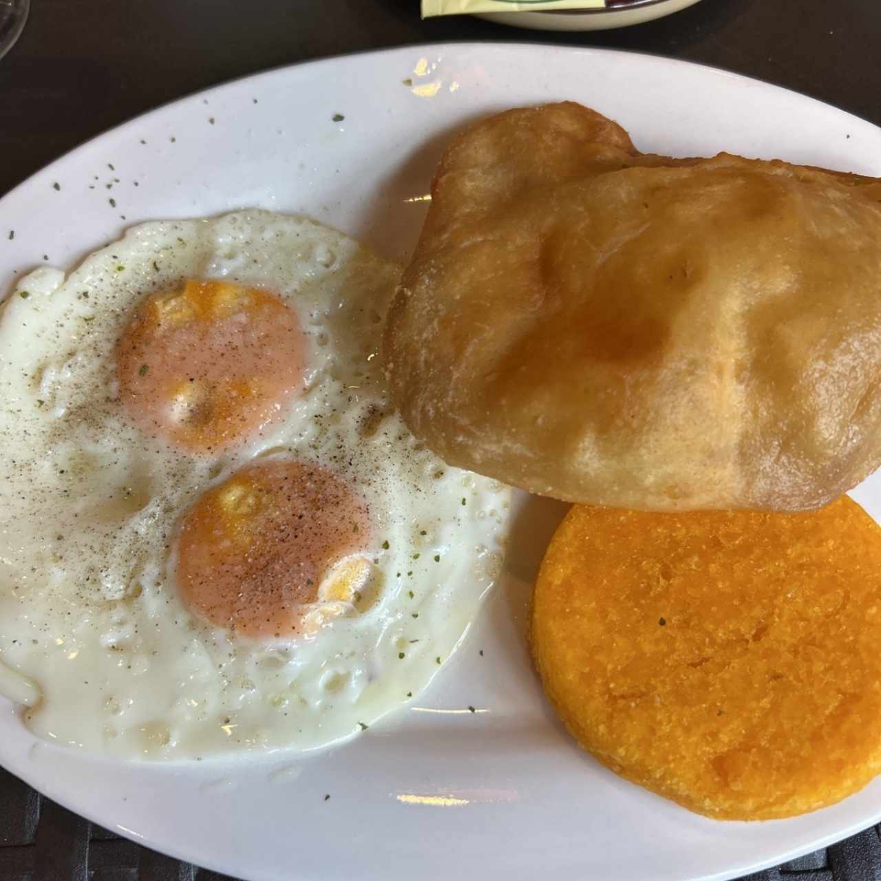 Huevos fritos con tocino, hojaldre y café o té negro