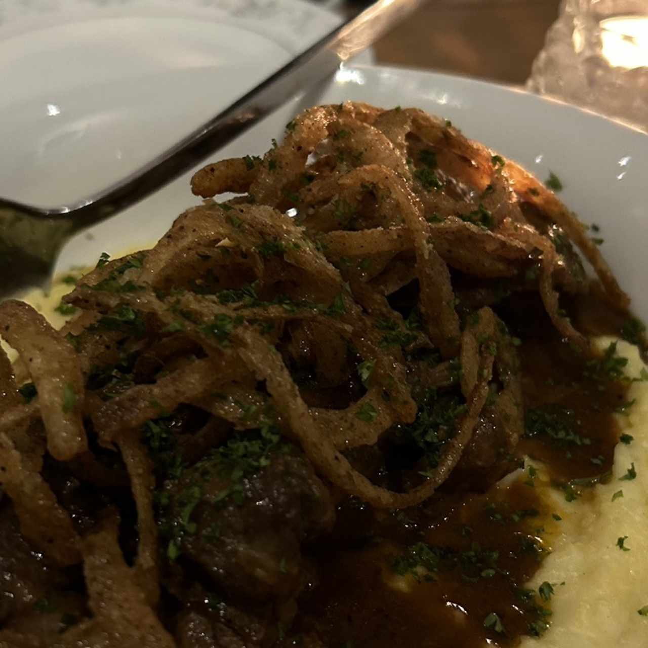 Ossobuco con polenta y cebollitas fritas