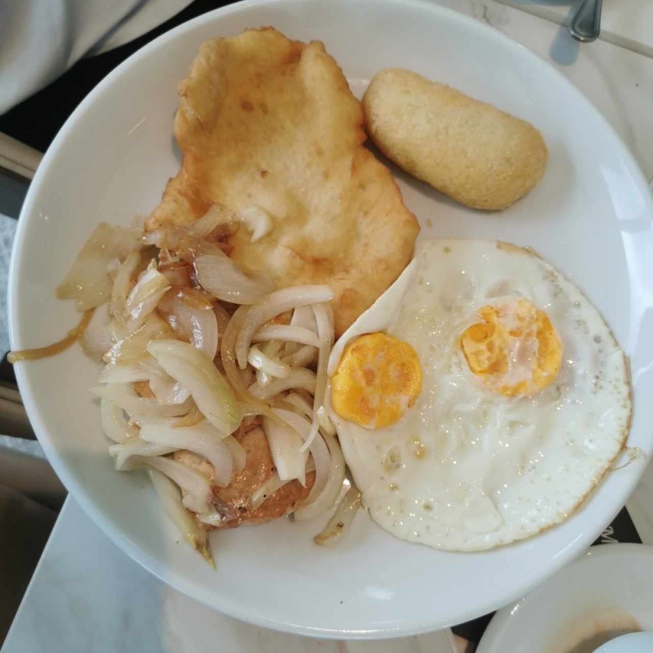 Pollo encebollado con hojaldre, carimañola y huevo frito