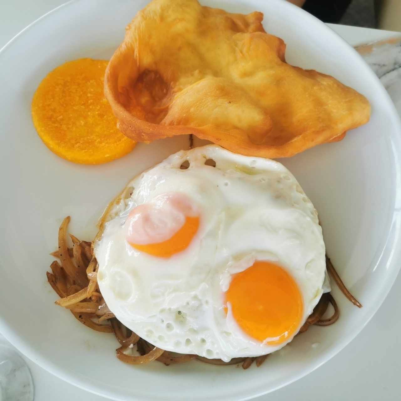 Desayuno panameño con hojaldre, tortilla y huevos fritos suaves. 