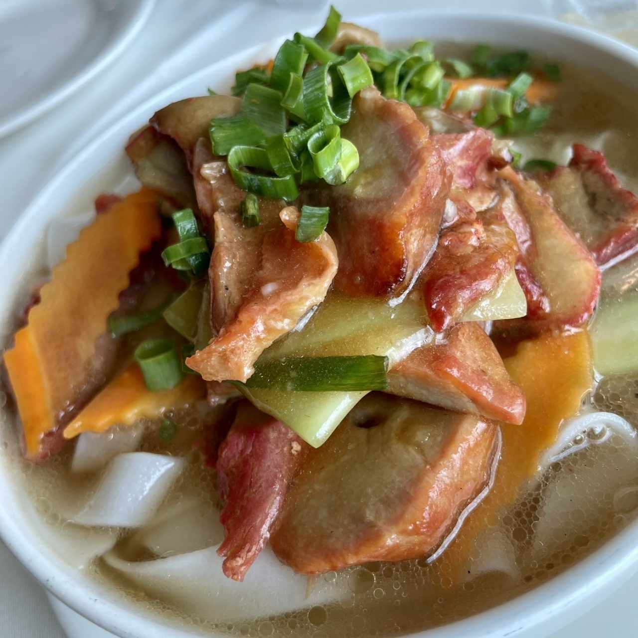 Tallarines de arroz en sopa con puerco liso asado