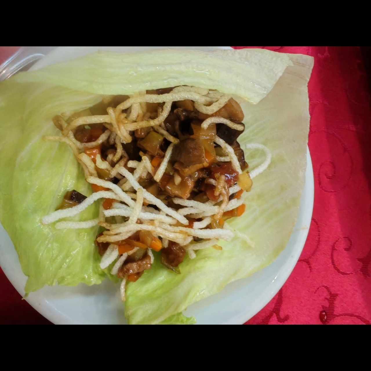 Taco de lechuga con fideo crocante y pato con vegetales 