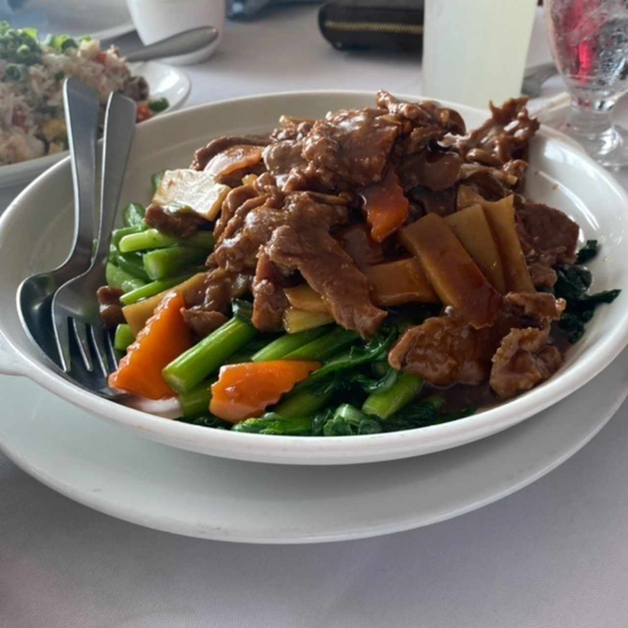 Carne con hojas de mostaza y en el fondo media orden de arroz de combinación delicioso