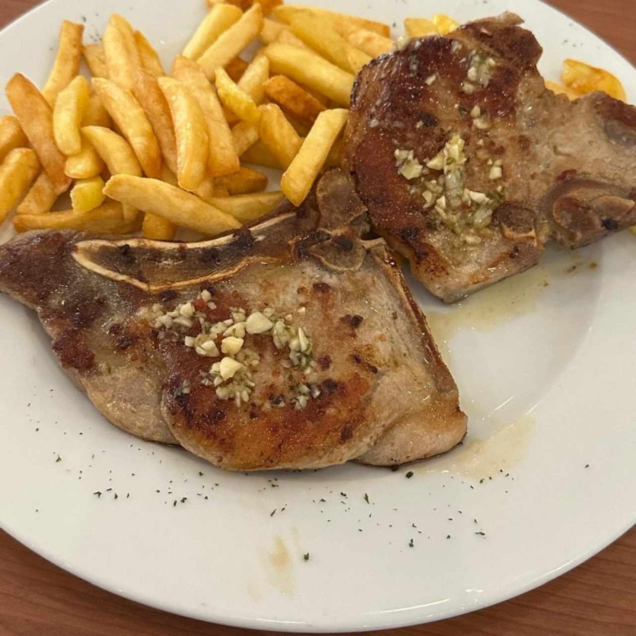 Chuleta a la Plancha o Al Ajillo y papas fritas 