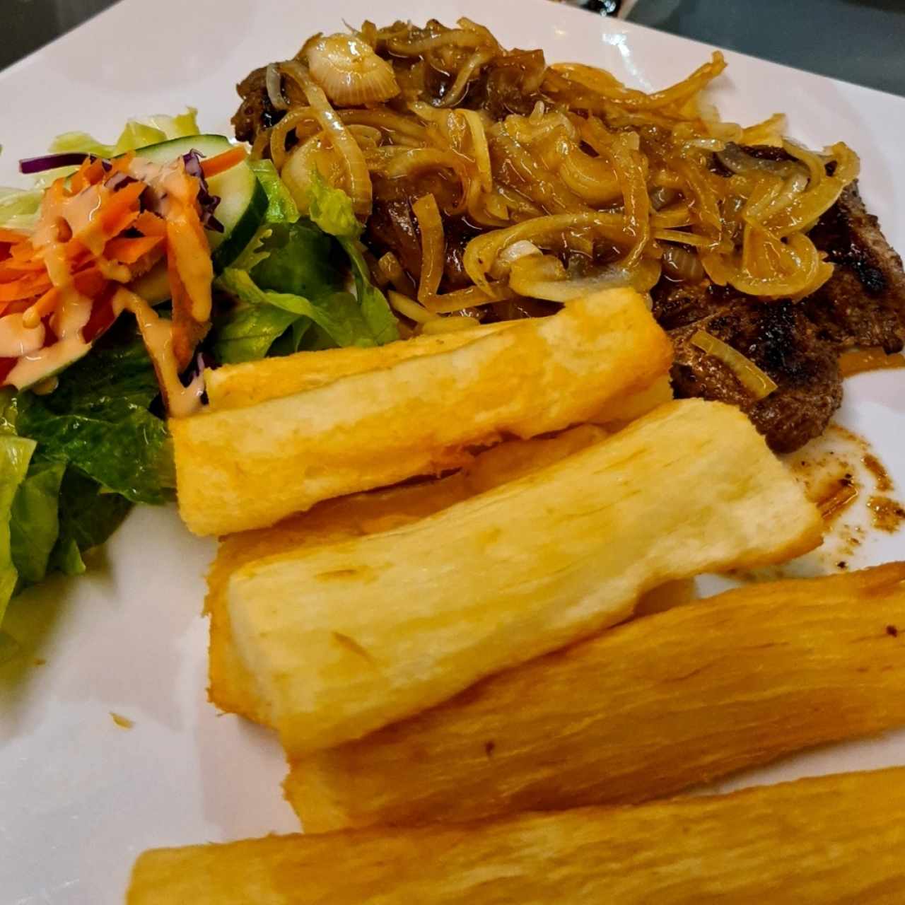 Rib Eye Encebollado con Yuca Frita