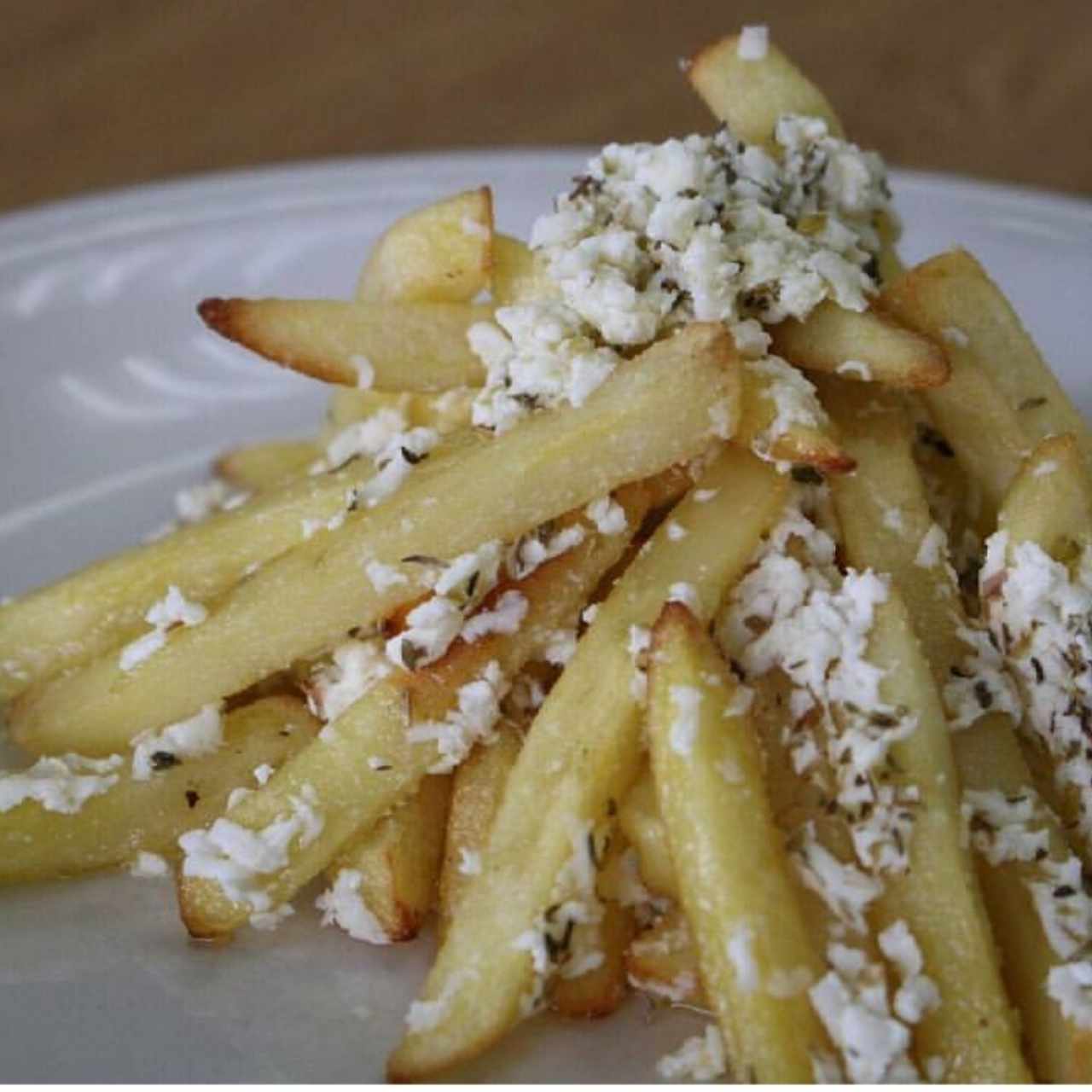 Papas asadas al horno con queso feta, aceite de oliva y orégano.