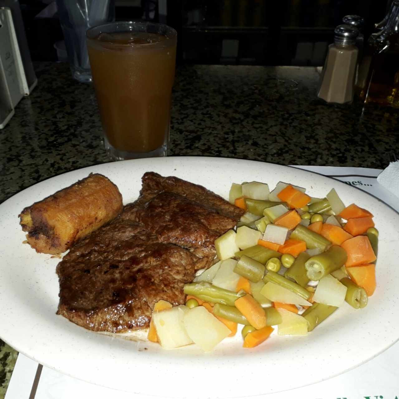 Churrasco con vegetales hervidos y plátano maduro, acompañado de una limonada con raspadura.