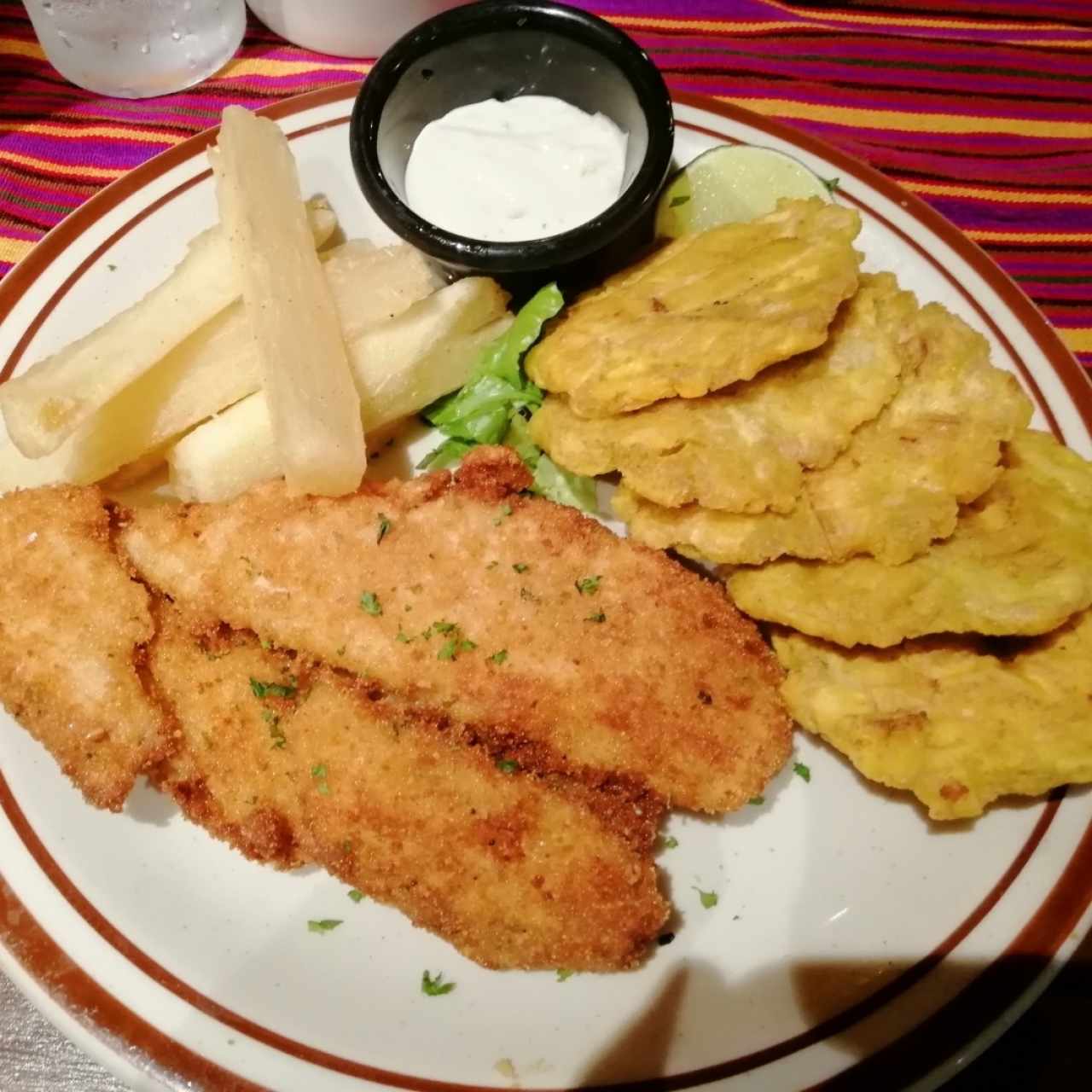 Filete de pescado apanado con yuca frita y patacones 