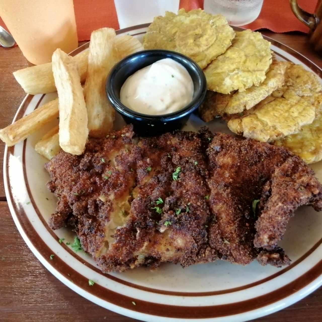 Corvina apanada con patacones y yuca frita 