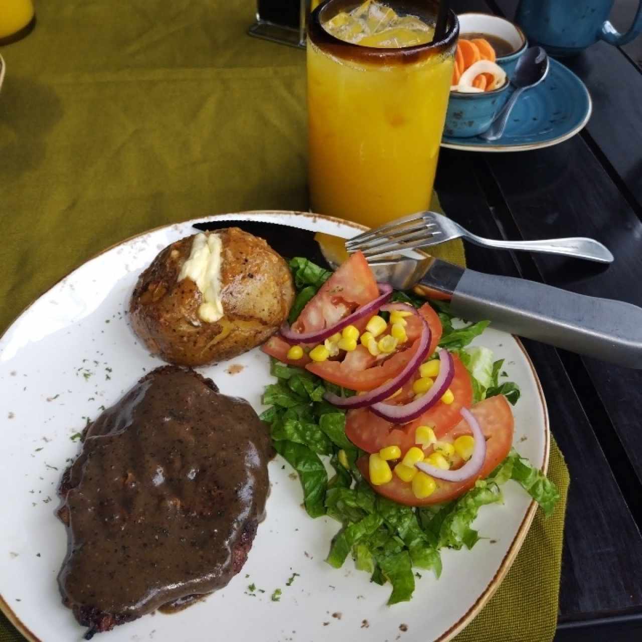 Steak pimienta con ensalda y papa asada  de acompañamientos