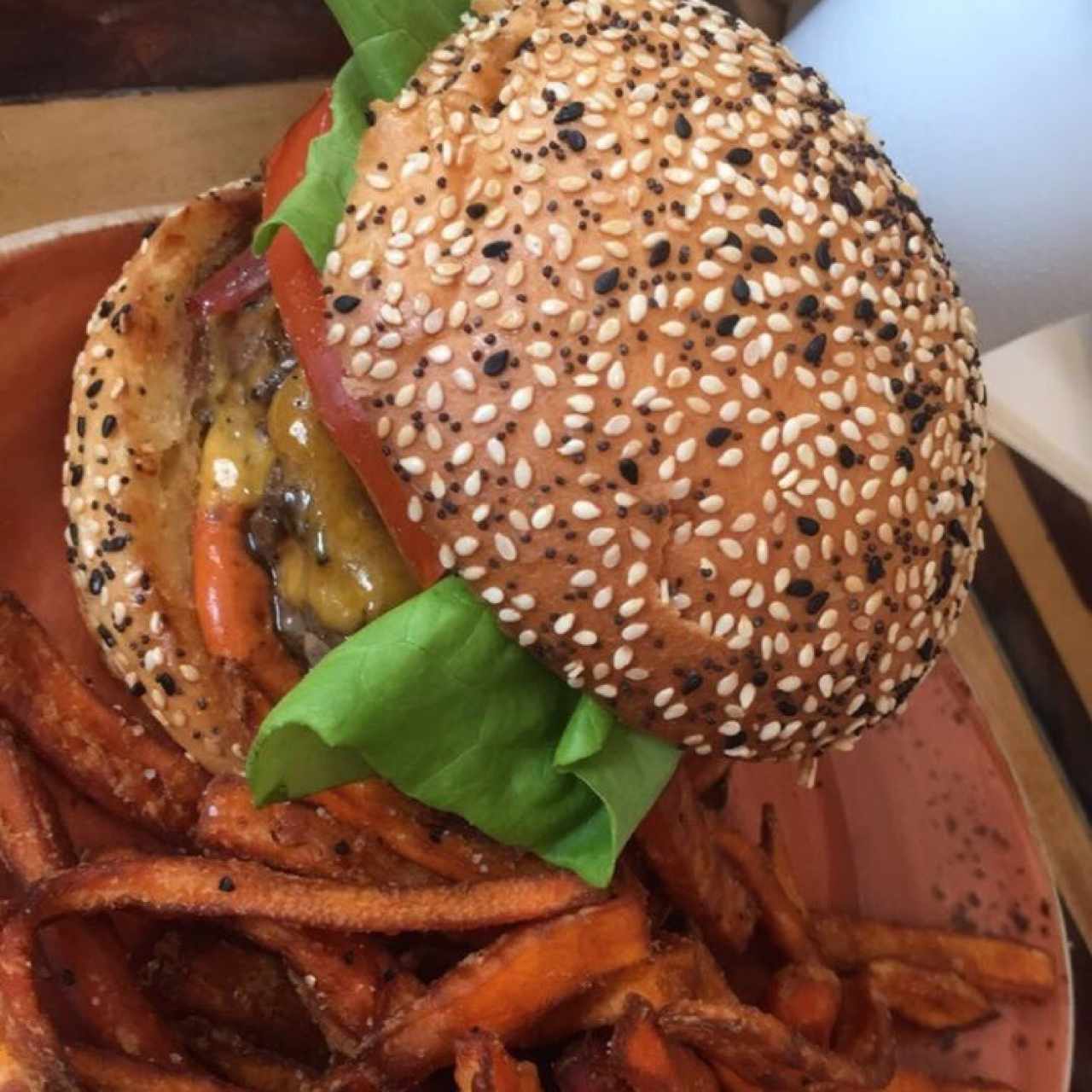 Hamburguesa tradicional con camote y miel a un lado