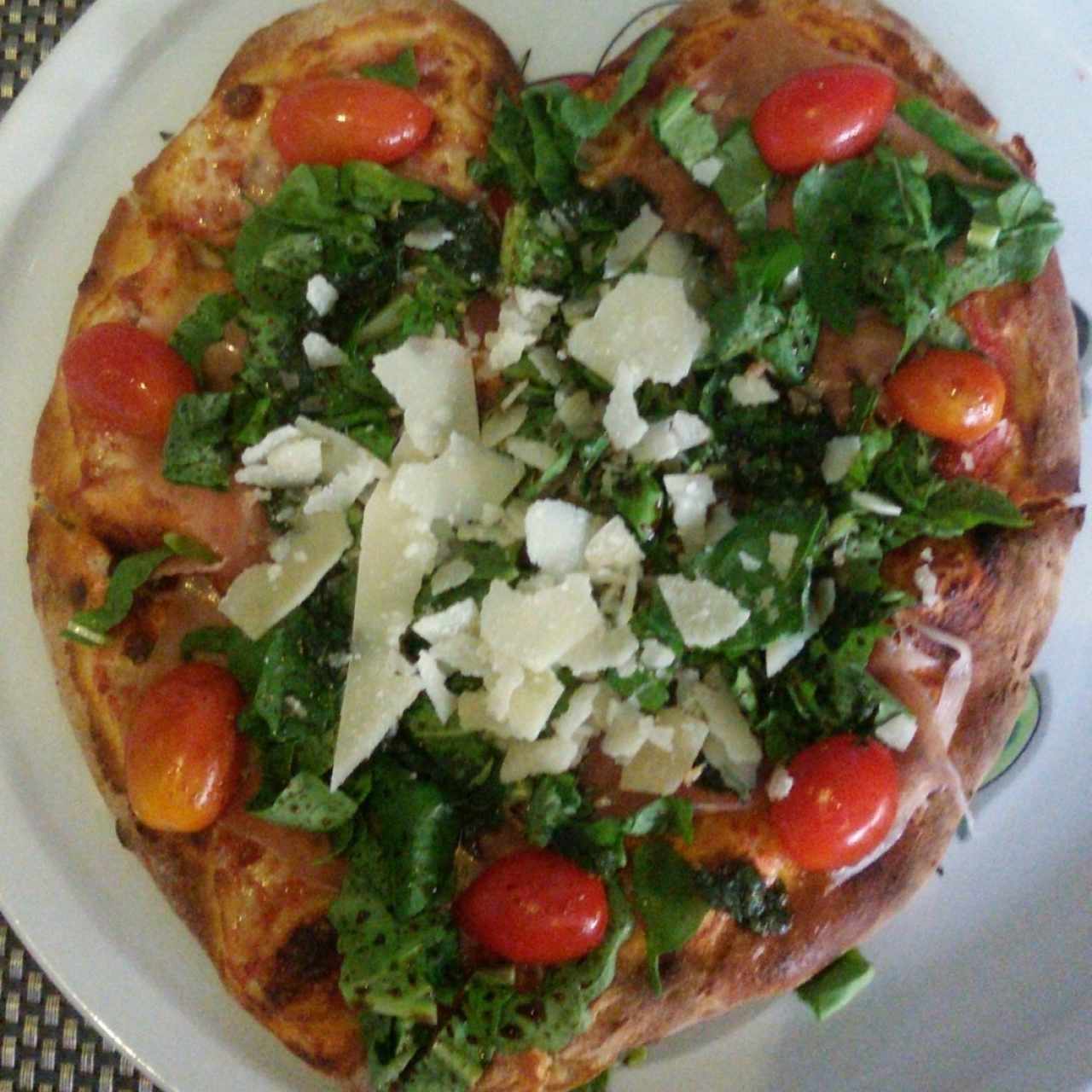 Pizza Rucula, Tomates Cherries, Jamón Serrano y láminas de Queso Parmesano.