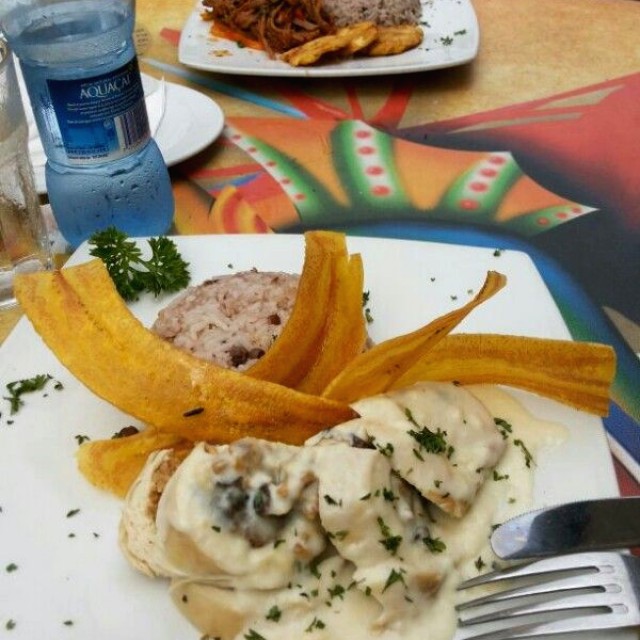 Pechuga rellena y al fondo ropa vieja, ambos con arroz con guandu 