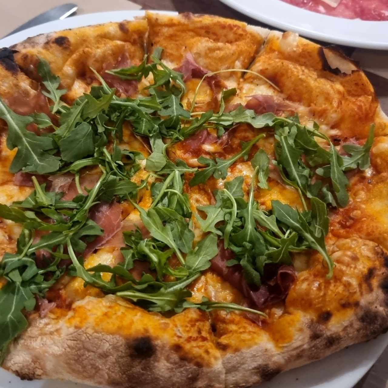 Pizza de proscuitto y arugula