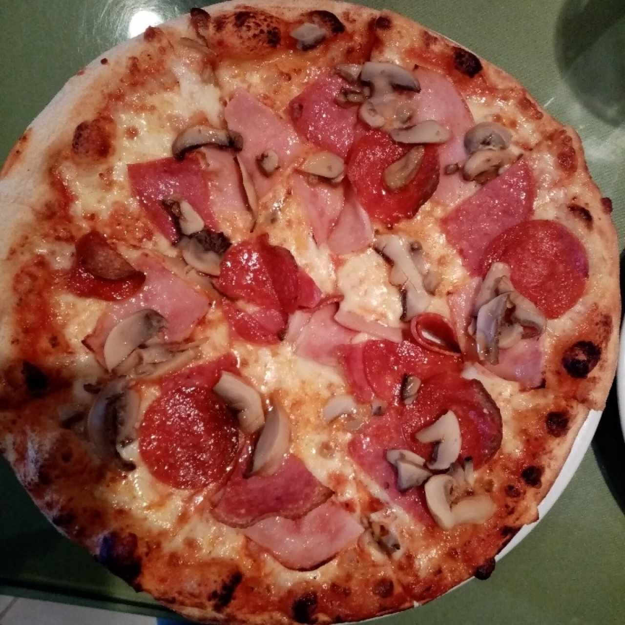 Pizza de peperoni, jamón, hongos 