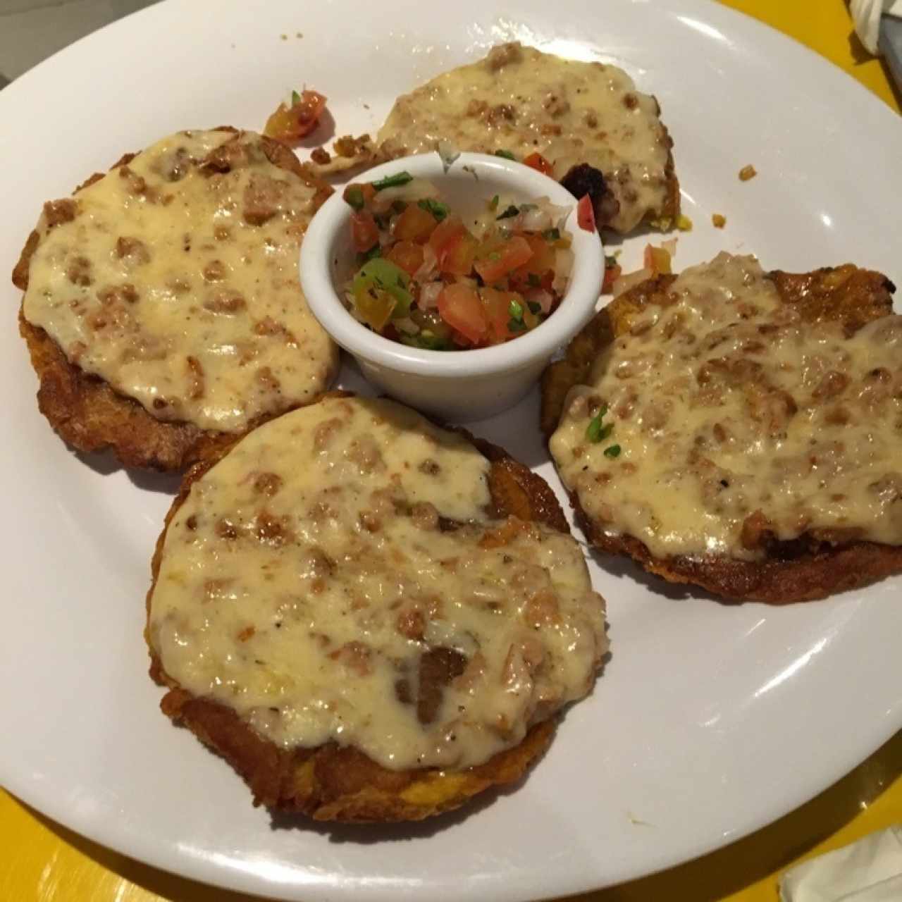 Patacones con chorizo y queso fundido