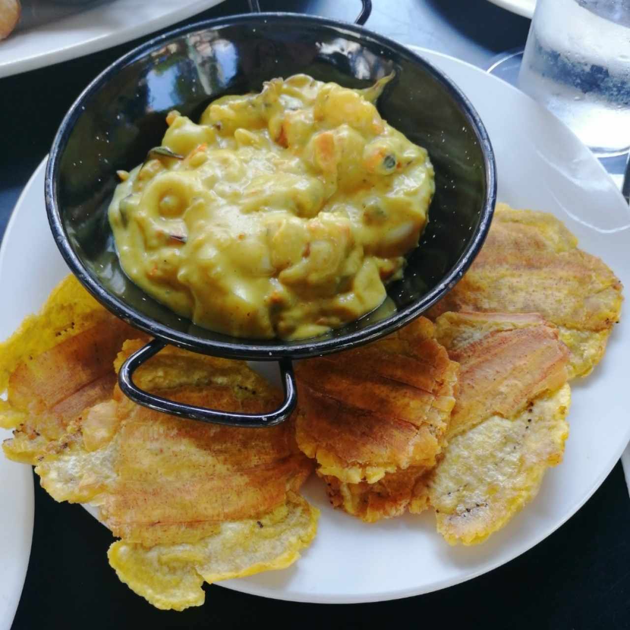 patacones con mariscos en salsa de curry y coco