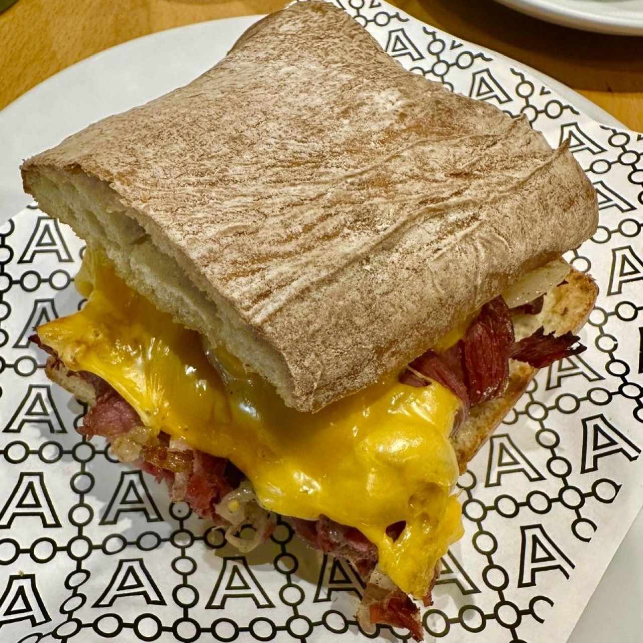 Pastrami de la Casa (Pan ciabatta plain, pastrami, queso cheddar, cebolla horneada y salsa pastrami) 
