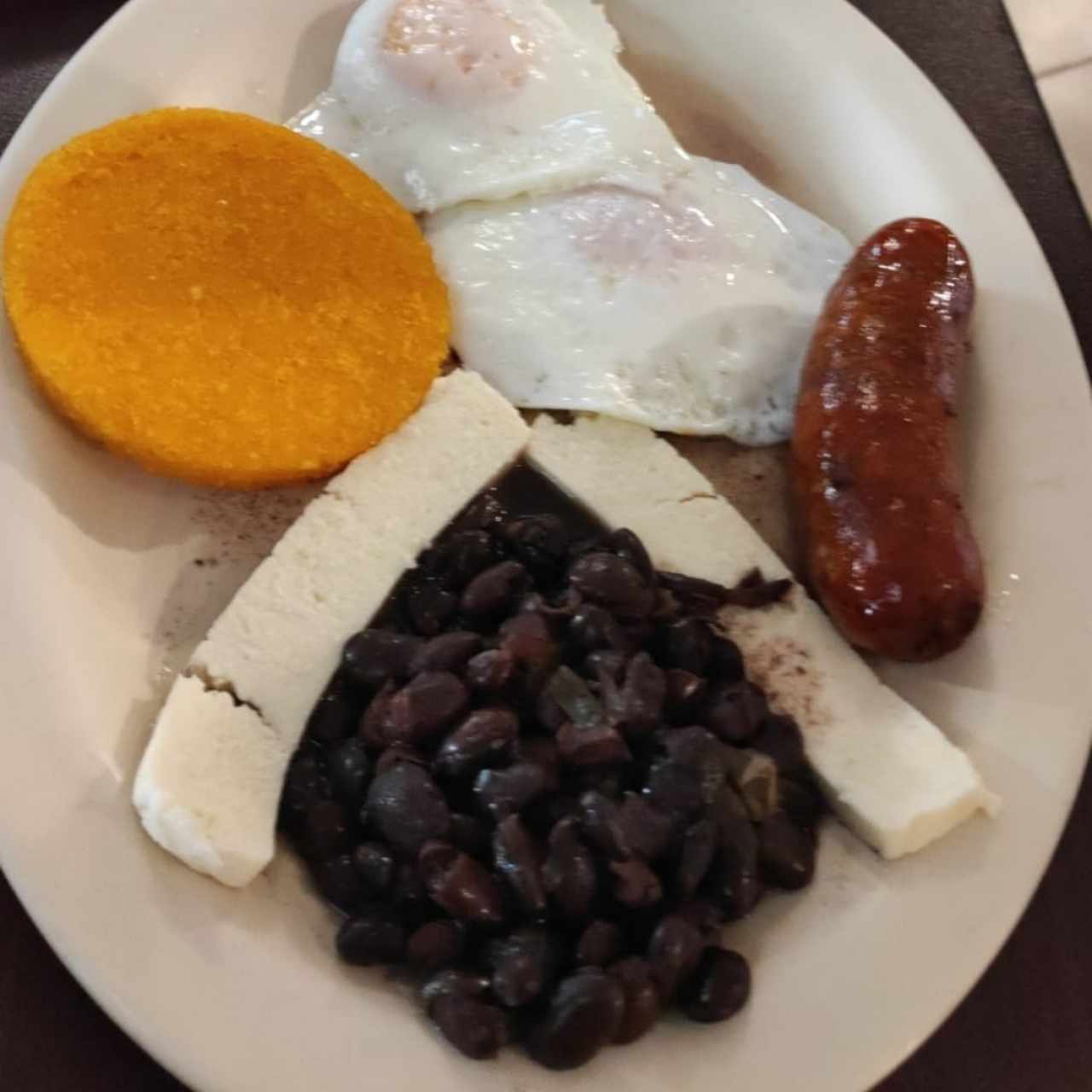 Huevos fritos, tortilla, chorizo tableño, queso blanco y frijoles negros