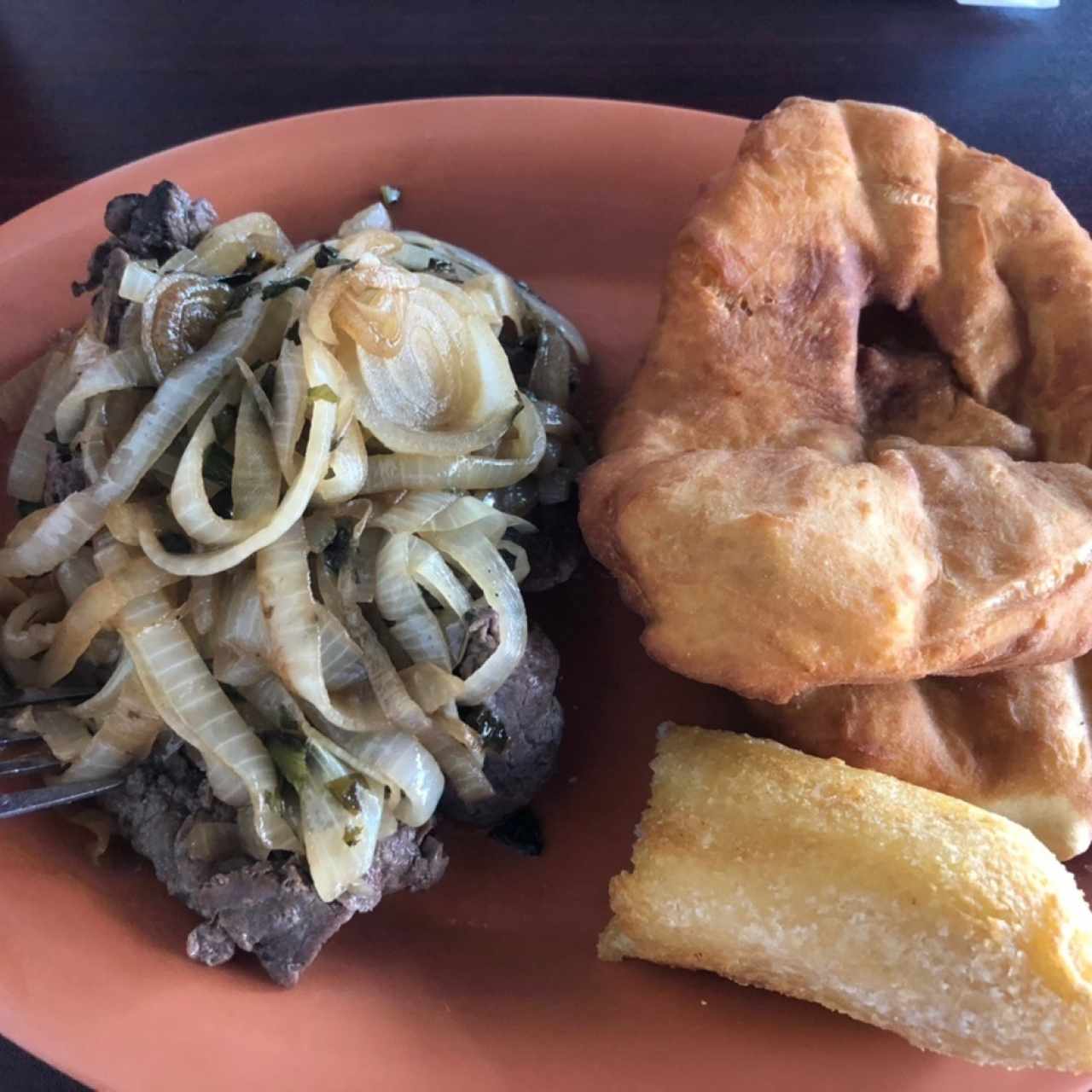 Bistec encebollado con hojaldre y carimañola