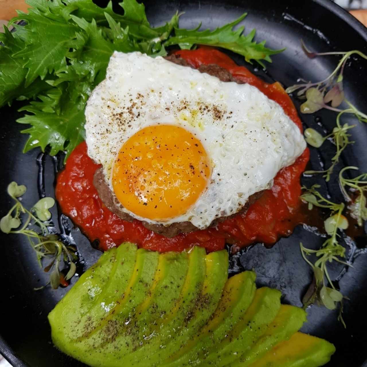 Opus Magnus: torta de carne en lecho de tomate al curry con un huevo